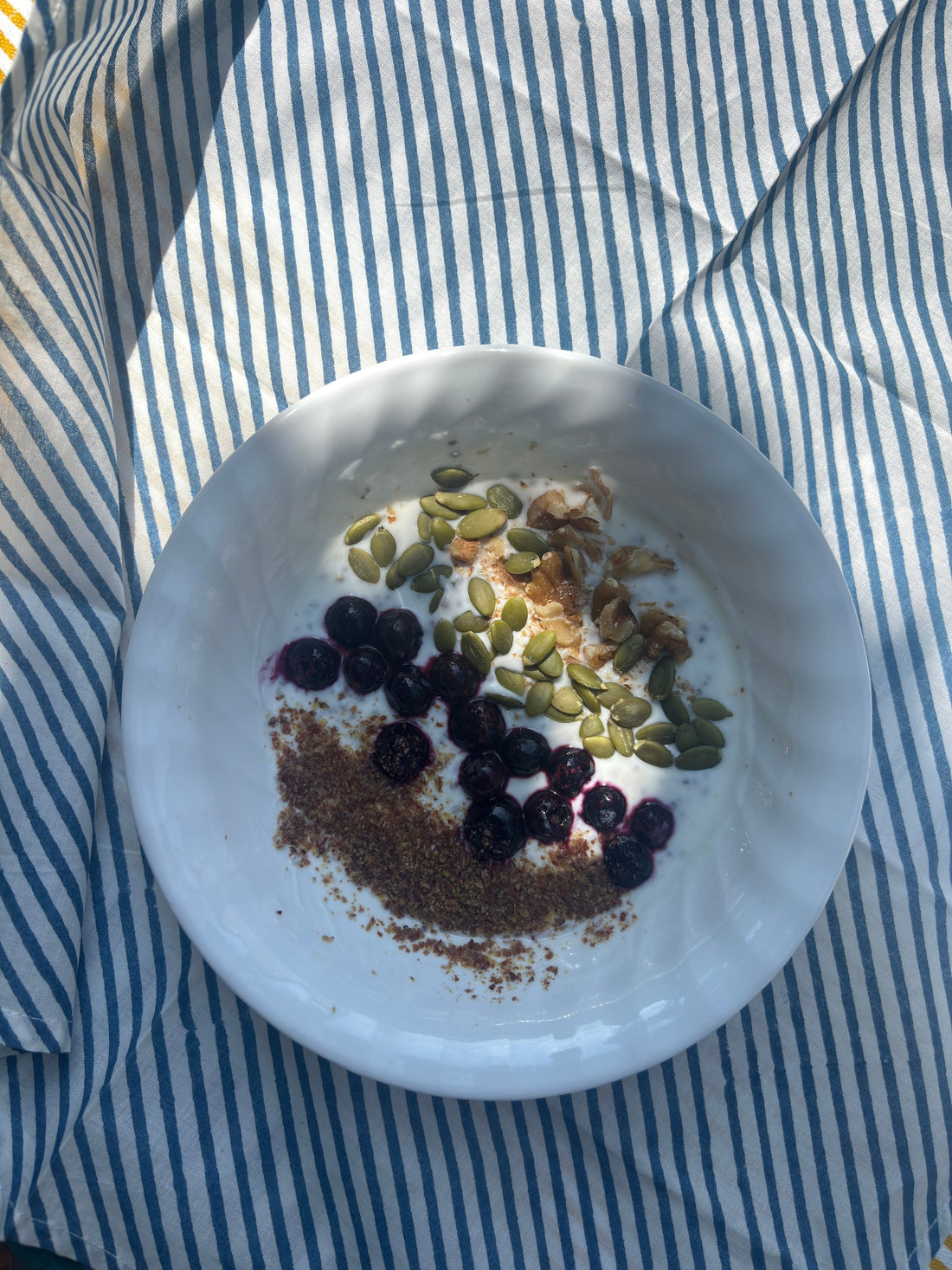 Smoothie bowl on handmade blue striped cotton napkin